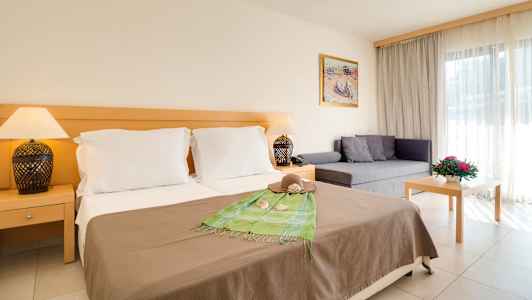 Hotellrum med dubbelsäng, soffa och bord. (AI-genererad text)