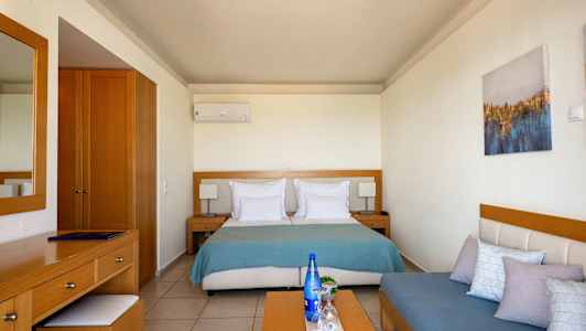 Ett hotellrum med en säng, en byrå och en soffa. (AI-genererad text)