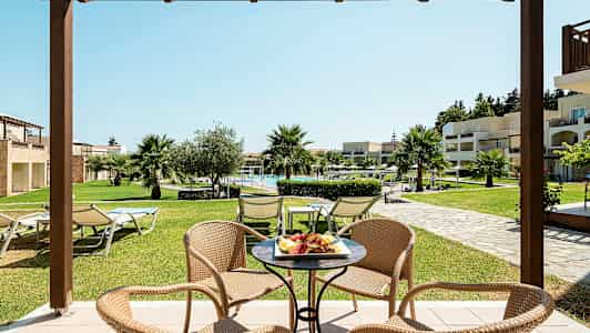 En sittgrupp med utsikt mot en grönskande trädgård och en pool. (AI-genererad text)