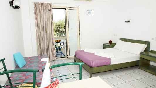 Ett hotellrum med en dubbelsäng, en soffa, ett bord med stolar och en balkong med utsikt. (AI-genererad text)