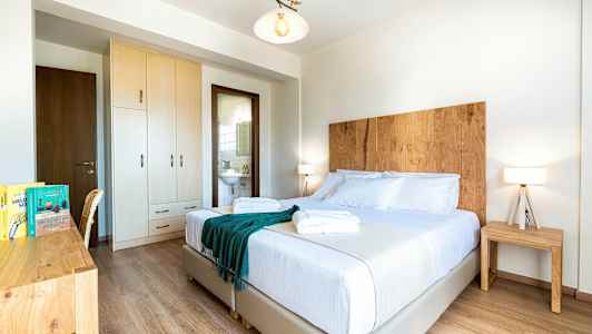 Ett ljust hotellrum med dubbelsäng, trädetaljer och är välstädat. (AI-genererad text)