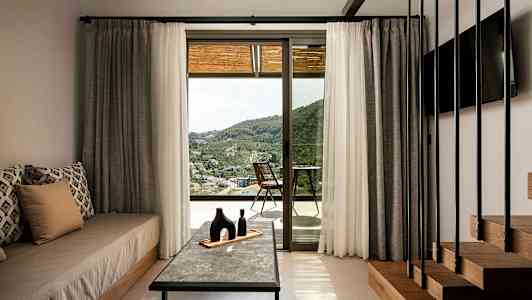 Rum med inredning och utsikt över landskapet genom en glasdörr. (AI-genererad text)