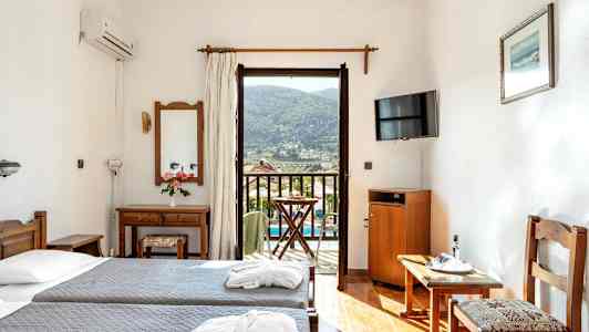 Hotellrum med två enkelsängar, spegel, TV och balkong med utsikt. (AI-genererad text)