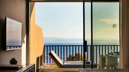 Utsikt från hotellrum med balkong mot havet. (AI-genererad text)