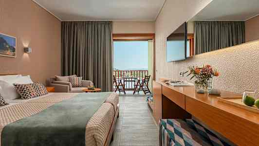 En hotellrum med dubbelsäng och balkongutsikt över landskap. (AI-genererad text)