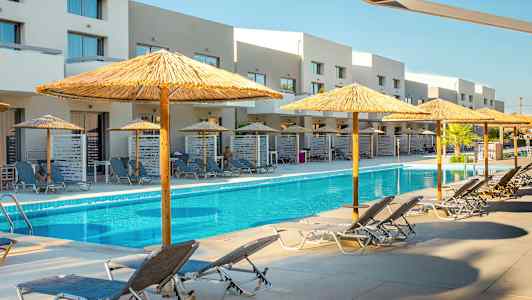 Utomhuspool med solstolar och parasoller samt byggnader i bakgrunden. (AI-genererad text)