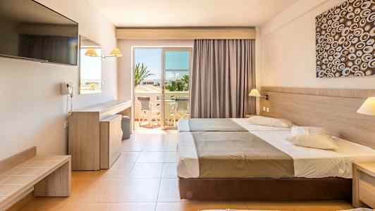 Hotellrum med två sängar, skrivbord, TV och en öppning till en balkong. (AI-genererad text)