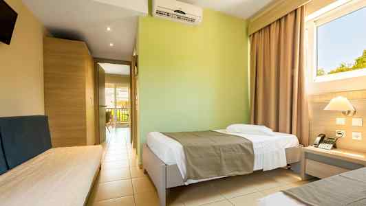 Ett hotellrum med enkelsängar och en fönstervy. (AI-genererad text)