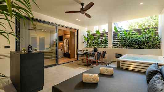 Privat terrass med jacuzzi, sittgrupp och solbädd. (AI-genererad text)