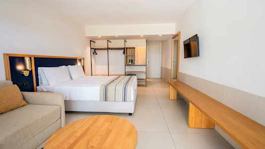 Ett modernt hotellrum med en dubbelsäng, soffa, och träinredning. (AI-genererad text)