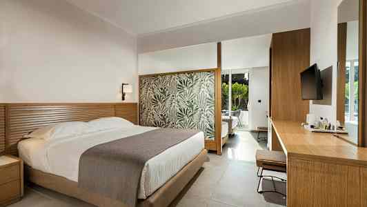 Ett hotellrum med en säng, träbord och en modern inredning. (AI-genererad text)