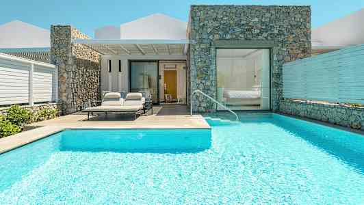 En villa med pool och solstolar vid ingången. (AI-genererad text)