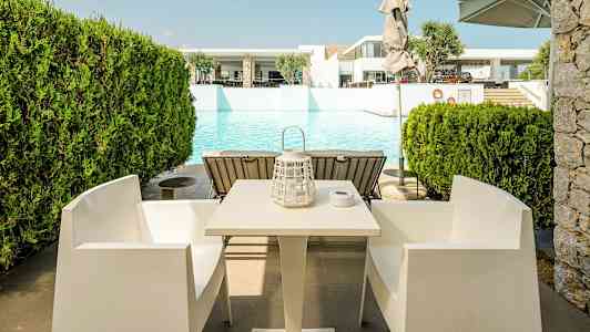 Bord och stolar framför en pool. (AI-genererad text)