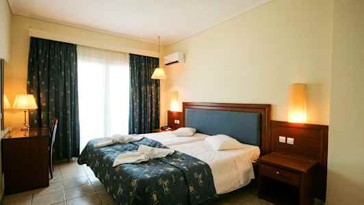 Bild av ett hotellrum med en dubbelsäng, skrivbord och nattduksbord. (AI-genererad text)