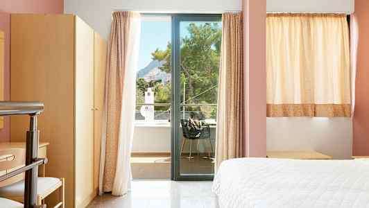 Hotellrum med fönster och balkongutsikt. (AI-genererad text)