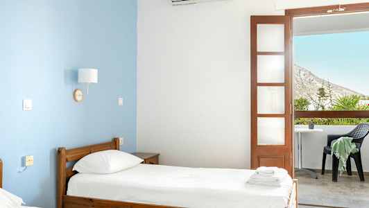 Ett hotellrum med två enkelsängar och en balkong med utsikt. (AI-genererad text)