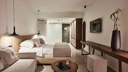 Ett modernt hotellrum med dubbelsäng, soffa och elegant inredning. (AI-genererad text)