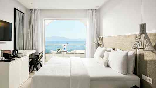 Hotellrum med dubbelsäng och havsutsikt. (AI-genererad text)