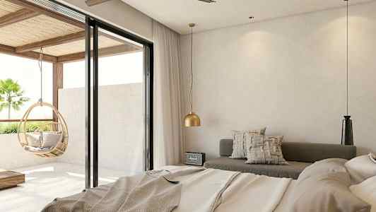 Ett hotellrum med modern design, med en säng, sittplats och stora glasdörrar som ger utsikt mot balkongen med en hängande korgstol. (AI-genererad text)