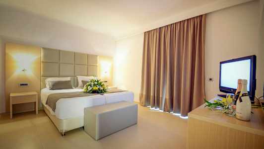 Hotellrum med en dubbelsäng och en blomsterdekoration. (AI-genererad text)