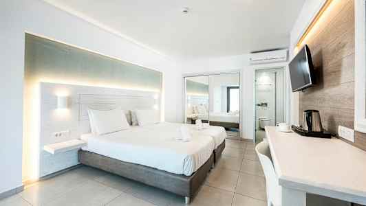 Modernt hotellrum med två bäddar, skrivbord och speglar. (AI-genererad text)