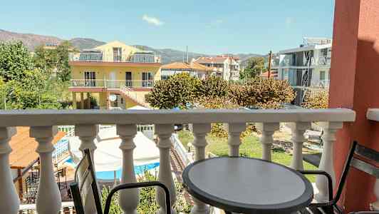 En balkong med utsikt över omgivande byggnader och natur. (AI-genererad text)