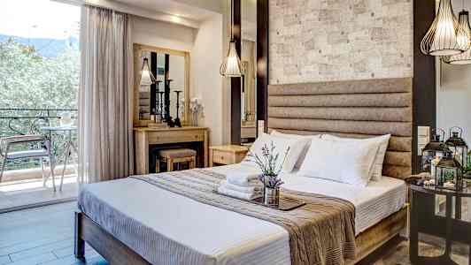 Ett hotellrum med en dubbelsäng, dekorativ belysning och en balkong med utsikt. (AI-genererad text)