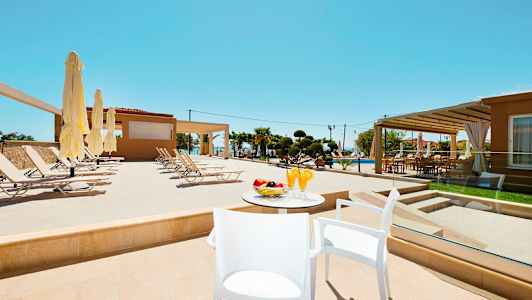 Solstolar vid en pool på ett hotell med bord och drinkar i förgrunden. (AI-genererad text)