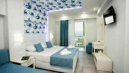 Interiör av ett modernt hotellrum med en dubbelsäng, blå detaljer och ett öppet fönster med utsikt. (AI-genererad text)