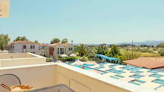 Utsikt från en terrass över hus, grönområden och landskap. (AI-genererad text)