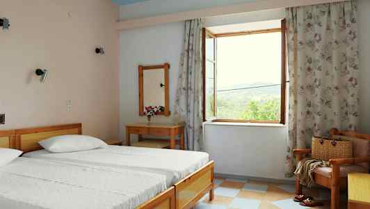 Ett sovrum med två sängar, ett skrivbord och en öppen fönsterutsikt. (AI-genererad text)