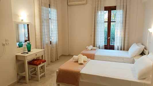 Ett hotellrum med två enkelsängar, ett skrivbord och en spegel. (AI-genererad text)