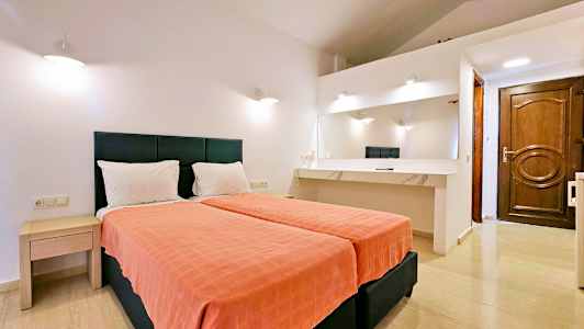 Hotellrum med två enkelsängar, ett skrivbord med spegel och vita väggar. (AI-genererad text)