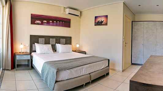 Ett hotellrum med en dubbelsäng, två nattduksbord och dekorativa väggbilder. (AI-genererad text)