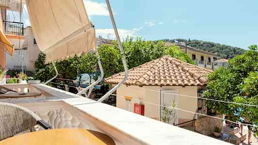 Utsikt över en solig terrass med tak och träd i bakgrunden. (AI-genererad text)