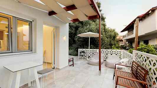 En terrass med utemöbler och en utsikt mot grönska. (AI-genererad text)