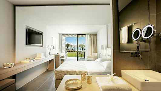 Modernt hotellrum med utsikt över en trädgård och hav. (AI-genererad text)