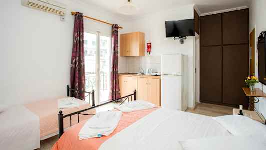 Hotellrum med tre bäddar, garderob, luftkonditionering och pentry. (AI-genererad text)