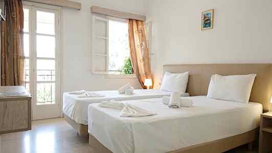 Ett hotellrum med två sängar, vita sängkläder och fönster med gardiner. (AI-genererad text)