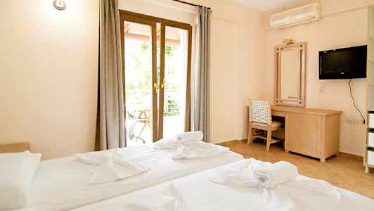 Hotellrum med två bäddar, skrivbord och TV. (AI-genererad text)