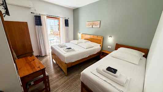 Hotelrum med två enkelsängar, ett skrivbord och en balkong. (AI-genererad text)
