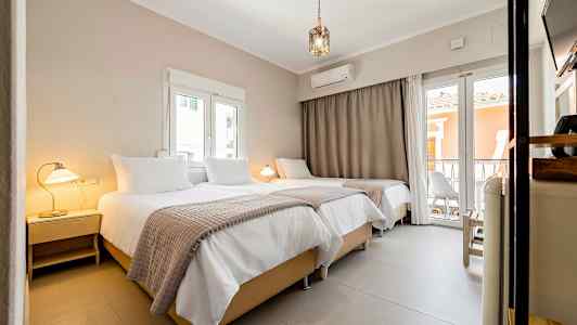 En interiör av ett hotellrum med tre sängar, lampor och fönster. (AI-genererad text)