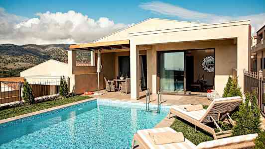 En villa med pool och solstolar framför en naturskön utsikt. (AI-genererad text)