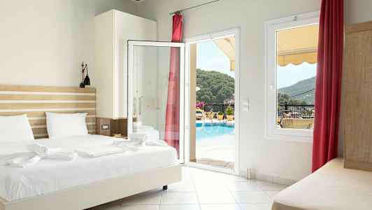 Hotellrum med säng, öppet glasparti och utsikt mot poolområde och omgivande grönska. (AI-genererad text)