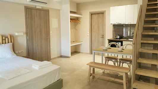 Ett modernt rum med säng, matbord, kök och trappa. (AI-genererad text)