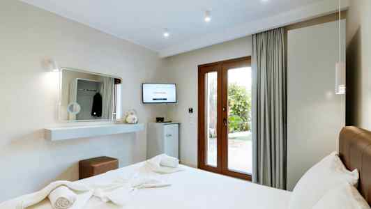 Modernt hotellrum med en dubbelsäng och utsikt mot trädgården. (AI-genererad text)