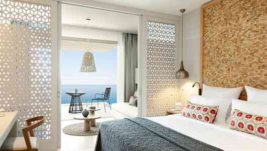 Modernt inrett hotellrum med utsikt över havet från en möblerad balkong. (AI-genererad text)