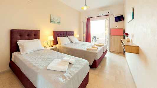 Ett hotellrum med två sängar, nattduksbord och en balkong. (AI-genererad text)