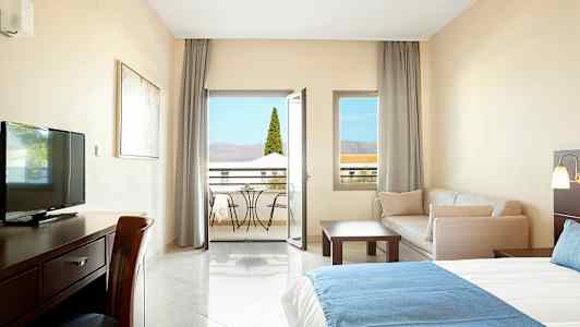 Hotellrum med möbler och balkong. (AI-genererad text)