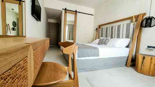 Modern hotellrumsinteriör med dubbelsäng och träinredning. (AI-genererad text)